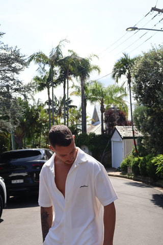 Men's elevated and comfortable terry towel button up. Going out top or beach top, good for holidays. White terry towel fabric button up, detailed navy embroidery across the back