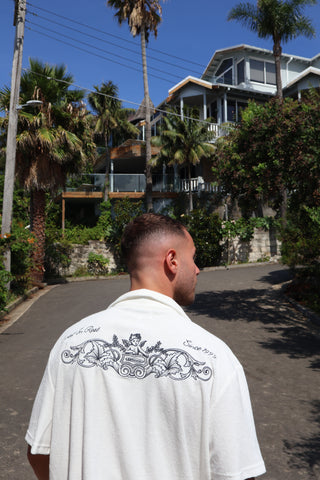 Men's elevated and comfortable terry towel button up. Going out top or beach top, good for holidays. White terry towel fabric button up, detailed navy embroidery across the back