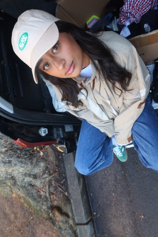 beige cap, green logo